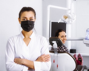 dentist in black mask with patient in office
