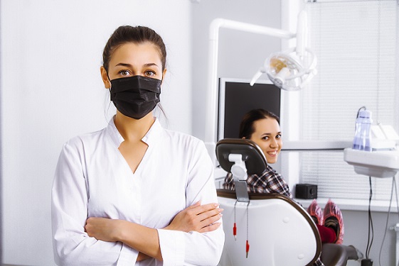 dentist in black mask with patient in office
