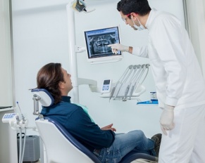 dentist showing patient image on monitor